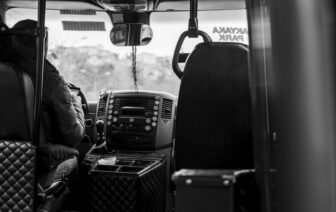 Een buschauffeur die passagiers veilig vervoert in een stadsbus, met aandacht voor de weg en de passagiers.