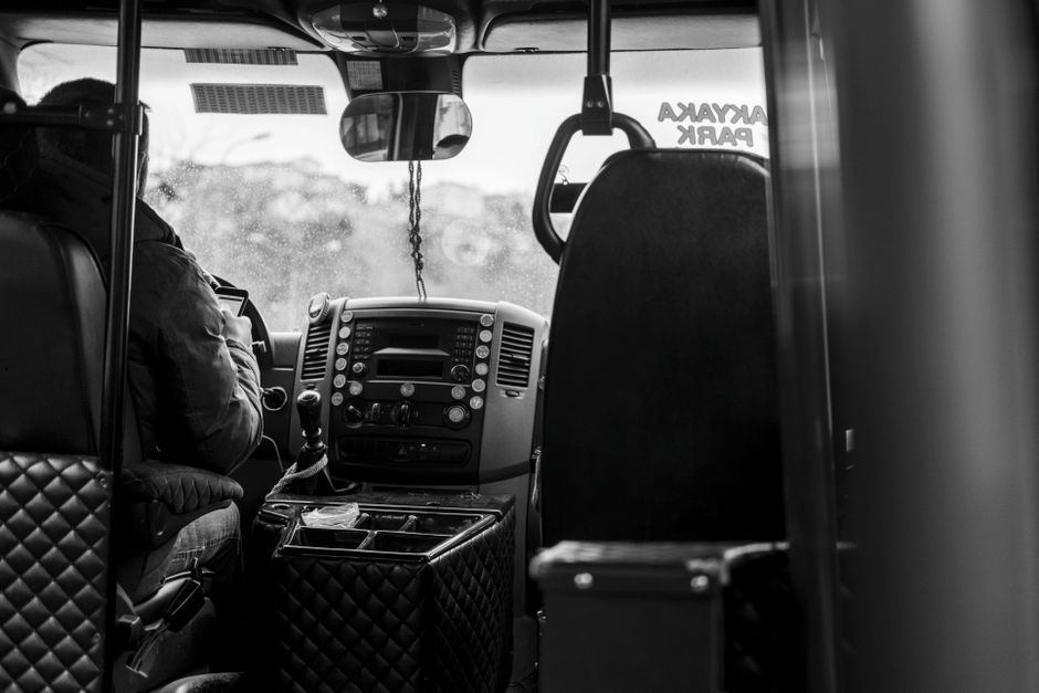 Een buschauffeur die passagiers veilig vervoert in een stadsbus, met aandacht voor de weg en de passagiers.